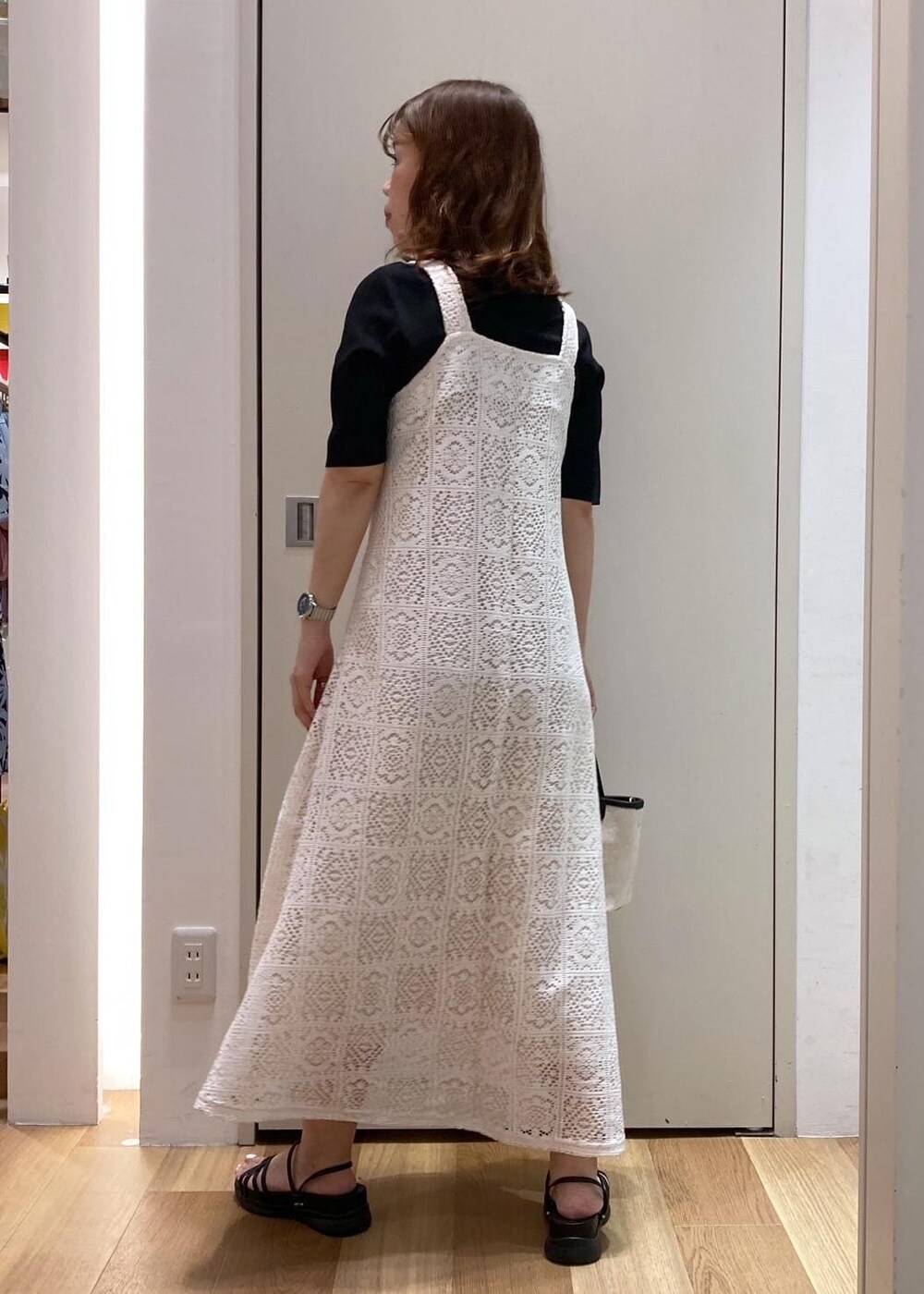 ブラック系のニット/セーター、ブラック系のトートバッグ、ブラック系のサンダルを着用したレディースの夏コーディネートの3枚目の写真