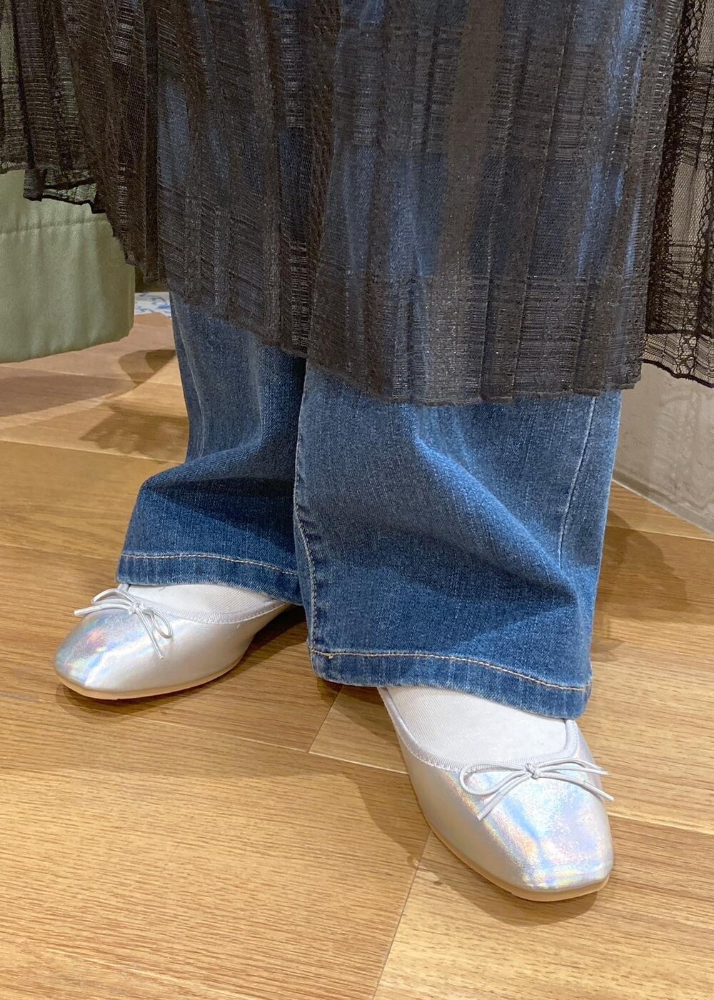 ブルー系のデニムパンツ、ブラック系のスカート、グリーン系のマウンテンパーカーを着用したレディースの春コーディネートの8枚目の写真