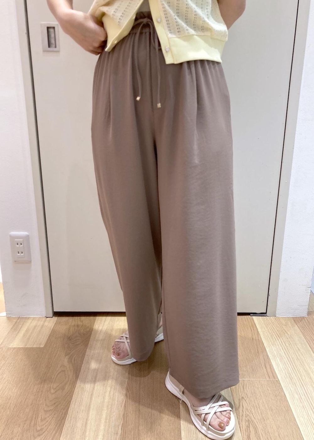 ホワイト系のサンダル、ブラウン系のその他パンツ、イエロー系のショルダーバッグを着用したレディースの夏コーディネートの4枚目の写真