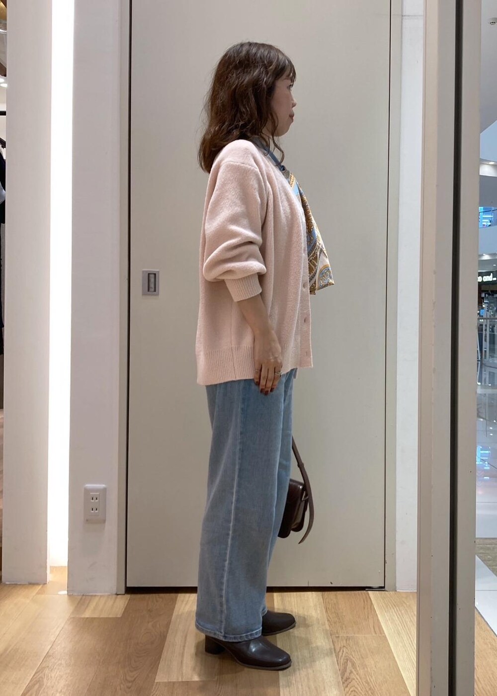 ピンク系のカーディガン/ボレロ、ホワイト系のTシャツ/カットソー、ブラウン系のブーツを着用したレディースの秋コーディネートの2枚目の写真