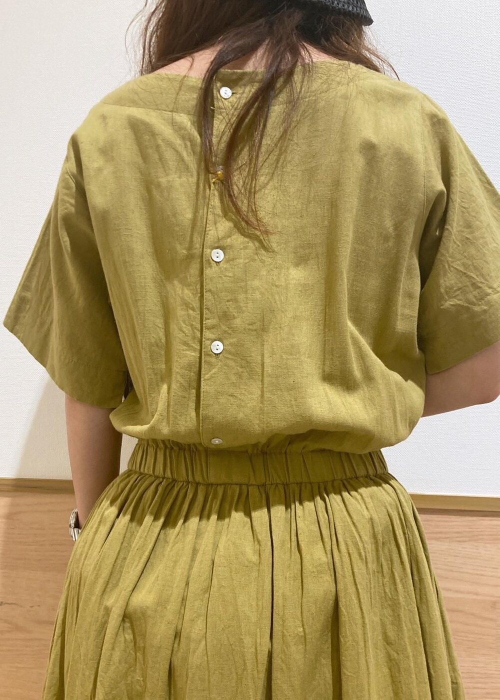 ブラック系のサンダル、ブラック系のかごバッグ、イエロー系のワンピースを着用したレディースの夏コーディネートの7枚目の写真