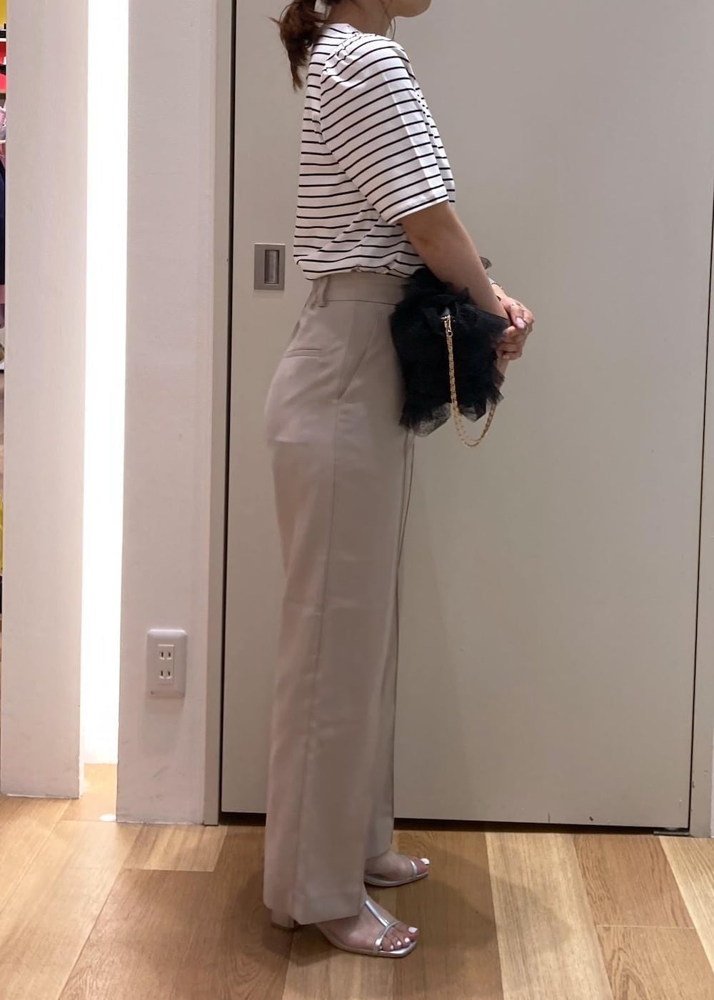 ブラック系のショルダーバッグ、シルバー系のパンプス、ベージュ系のその他パンツを着用したレディースの夏コーディネートの2枚目の写真