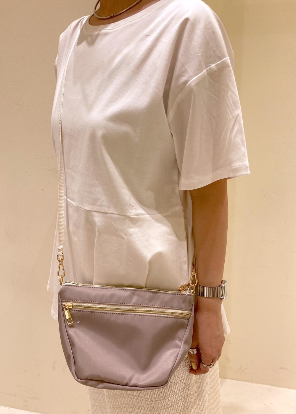 オレンジ系のシャツ/ブラウス、ベージュ系のショルダーバッグ、ホワイト系のTシャツ/カットソーを着用したレディースの春コーディネートの6枚目の写真