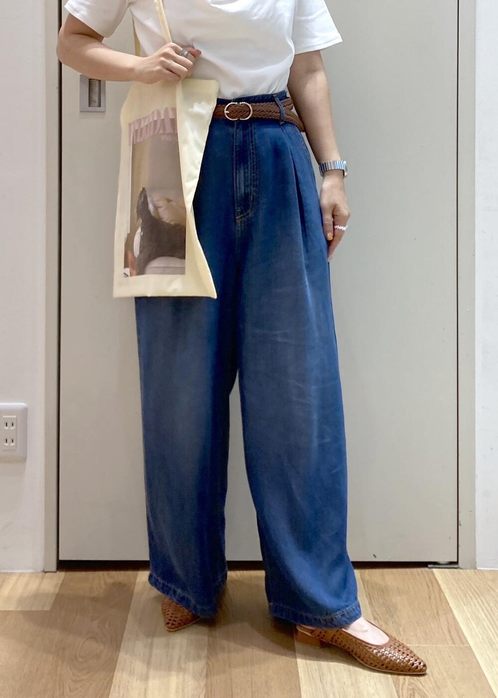ブラウン系のパンプス、イエロー系のトートバッグ、ブルー系のデニムパンツを着用したレディースの夏コーディネートの5枚目の写真