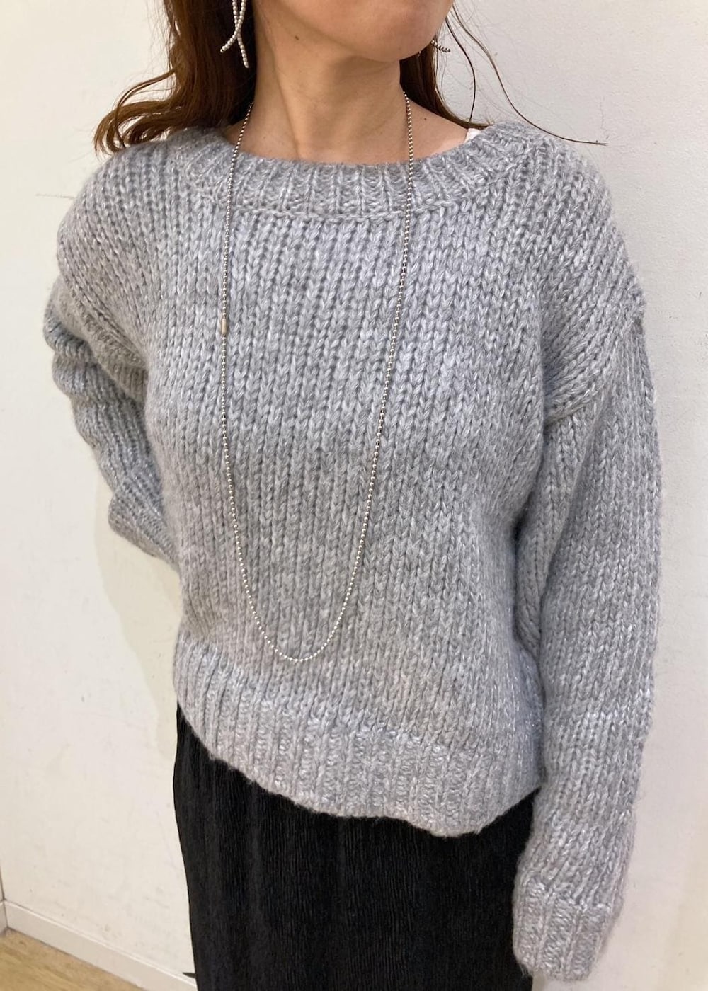 ホワイト系のTシャツ/カットソー、グレー系のニット/セーター、レッド系のトートバッグを着用したレディースの冬コーディネートの6枚目の写真