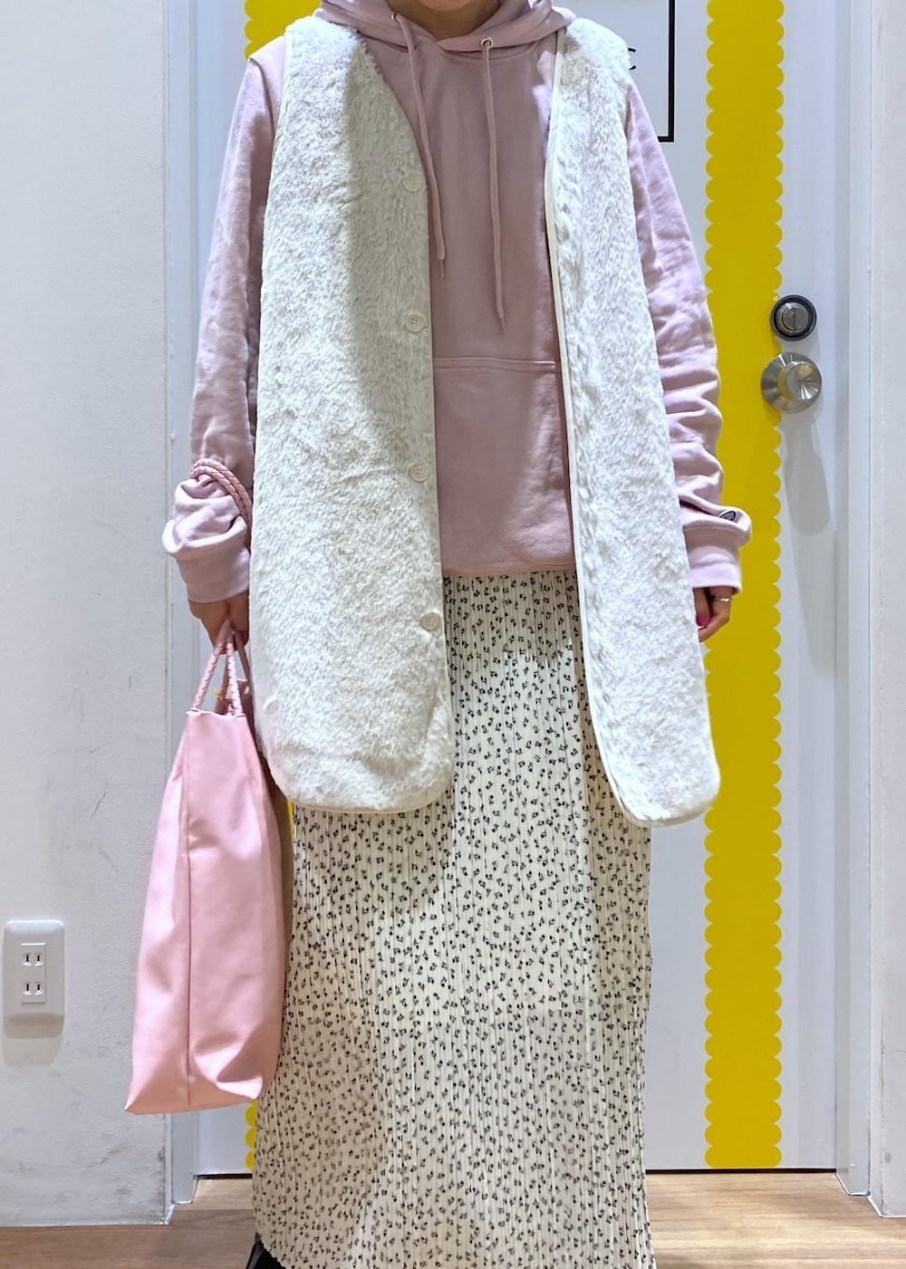 ホワイト系のスカート、ベージュ系のその他アウター、ピンク系のパーカーを着用したレディースの冬コーディネートの2枚目の写真