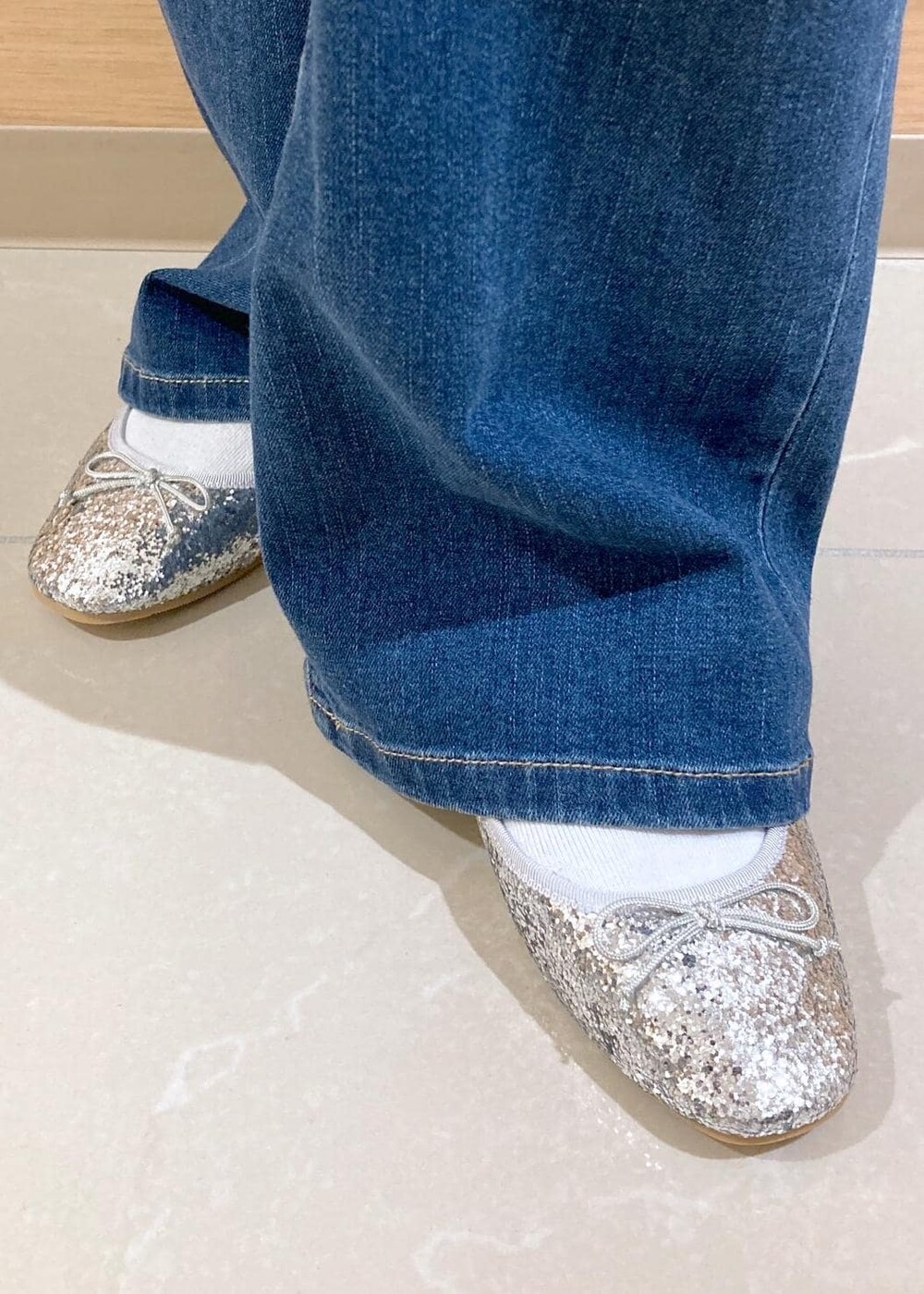 ホワイト系のTシャツ/カットソー、ブルー系のデニムパンツ、グレー系のワンピースを着用したレディースの秋コーディネートの9枚目の写真