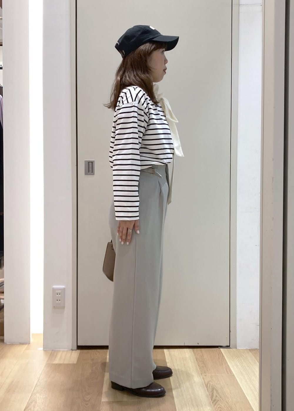 ブラック系のTシャツ/カットソー、ブラウン系のローファー、グリーン系のその他パンツを着用したレディースの冬コーディネートの2枚目の写真