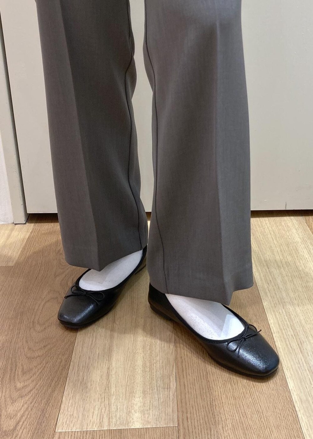 グレー系のスラックス、ベージュ系のカーディガン/ボレロ、ブラック系のバレエシューズを着用したレディースの春コーディネートの6枚目の写真