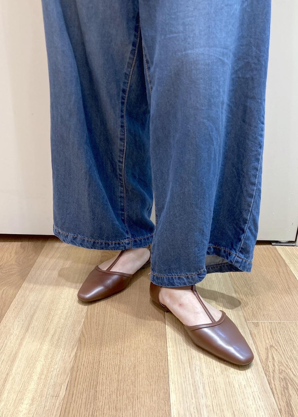 ブラウン系のパンプス、ブルー系のデニムパンツ、レッド系のトートバッグを着用したレディースの夏コーディネートの6枚目の写真
