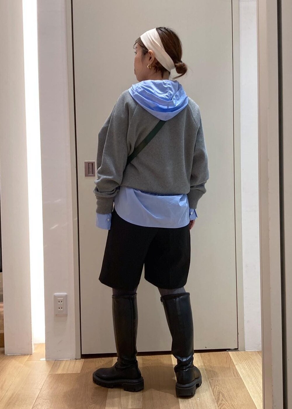 グリーン系のショルダーバッグ、ブルー系のシャツ/ブラウス、グレー系のニット/セーターを着用したレディースの秋コーディネートの3枚目の写真