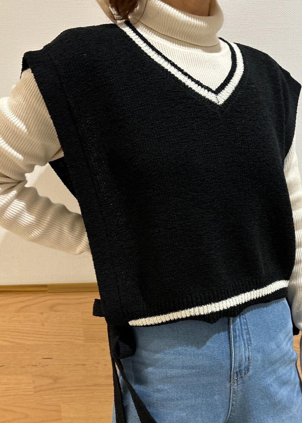 ホワイト系のニット/セーター、ブラック系のローファー、ブラック系のベストを着用したレディースの冬コーディネートの2枚目の写真