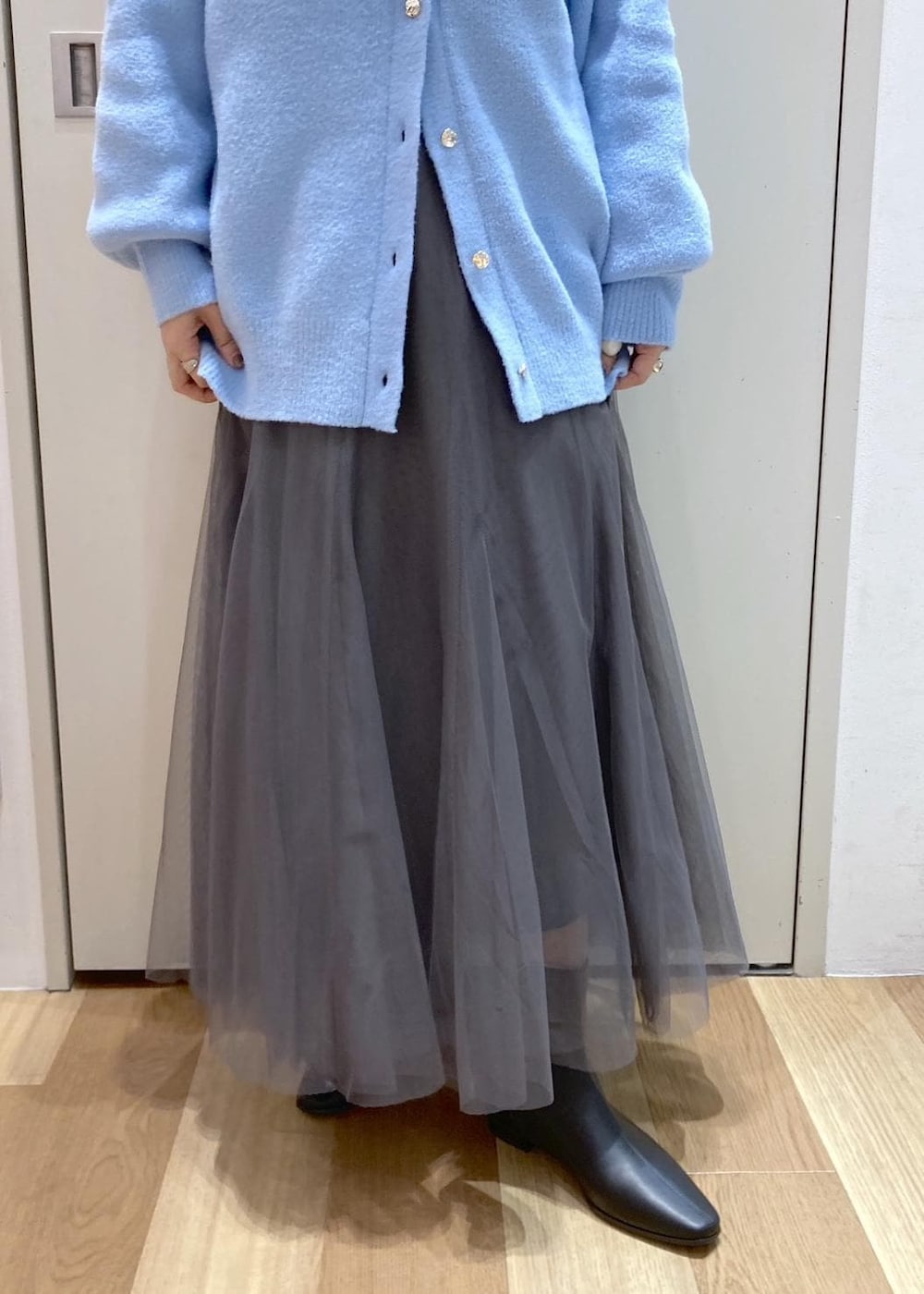 ブルー系のカーディガン/ボレロ、グレー系のスカート、ホワイト系のシャツ/ブラウスを着用したレディースの秋コーディネートの6枚目の写真