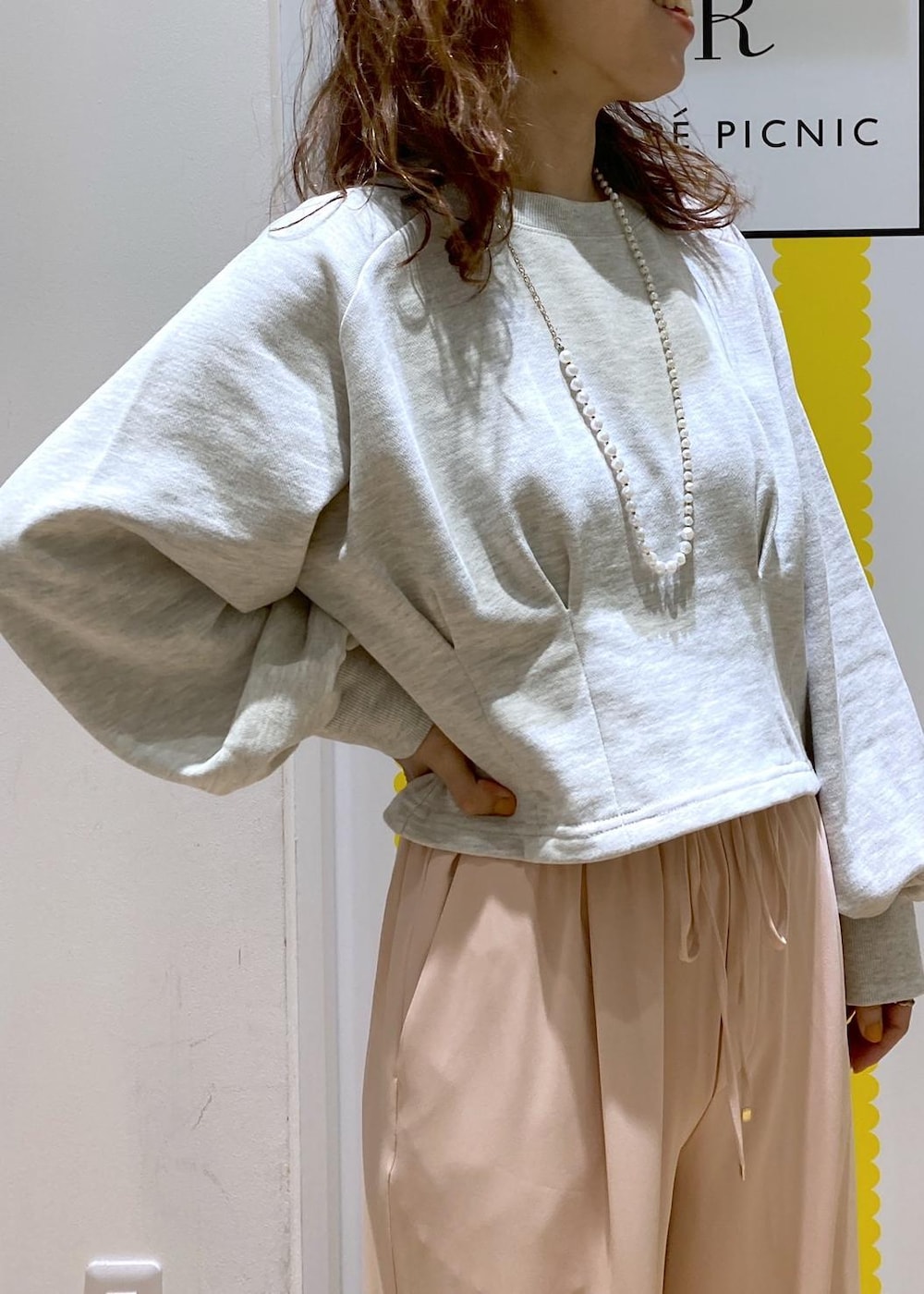 グレー系のスウェット、シルバー系のショルダーバッグ、ピンク系のその他パンツを着用したレディースの冬コーディネートの2枚目の写真