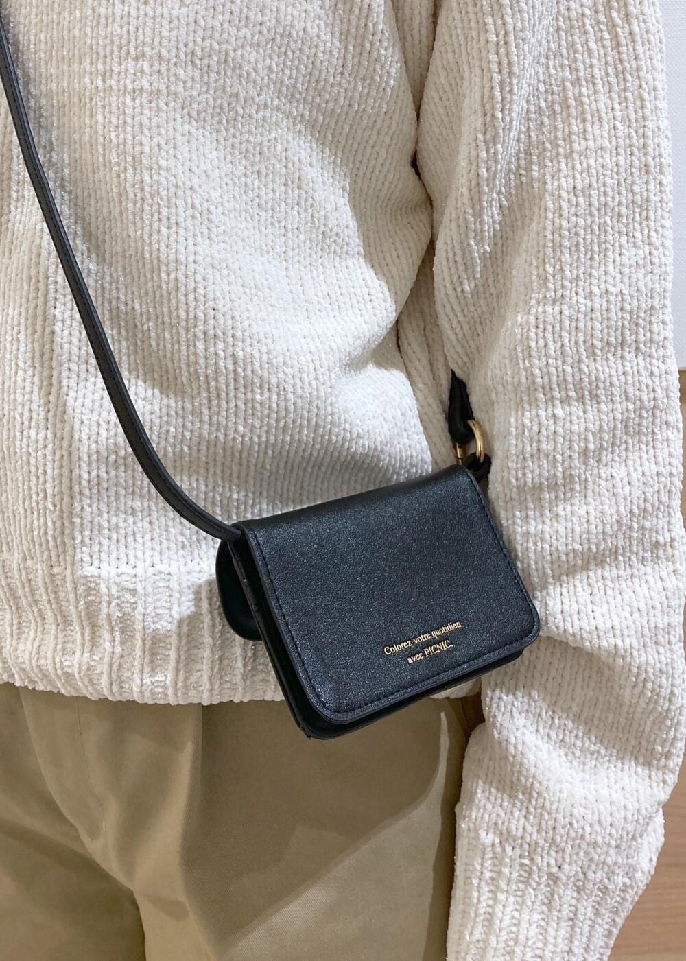 ホワイト系のニット/セーター、ブラック系のバレエシューズ、ベージュ系のチノパンツを着用したレディースの冬コーディネートの8枚目の写真