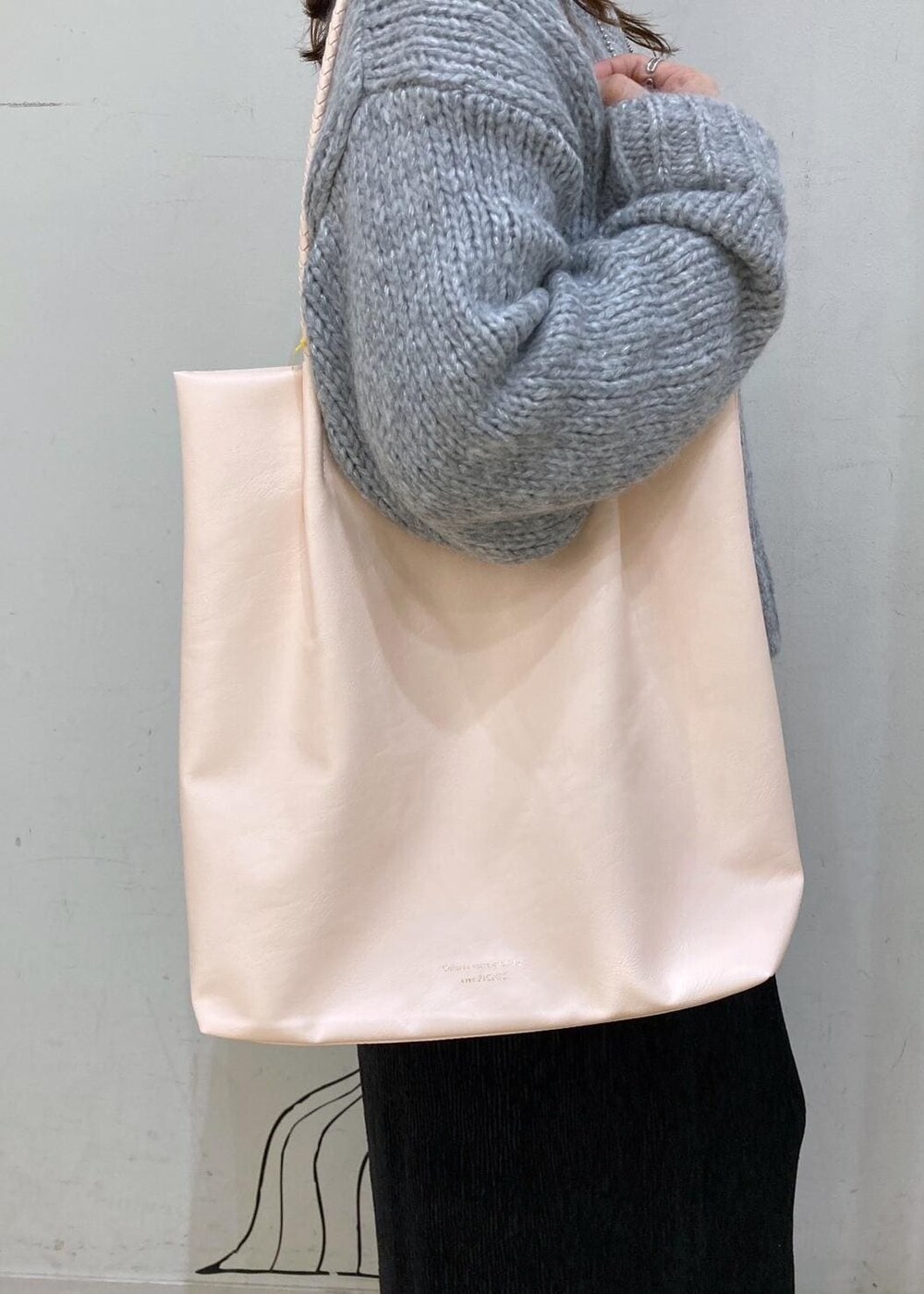 ホワイト系のTシャツ/カットソー、グレー系のニット/セーター、レッド系のトートバッグを着用したレディースの冬コーディネートの10枚目の写真