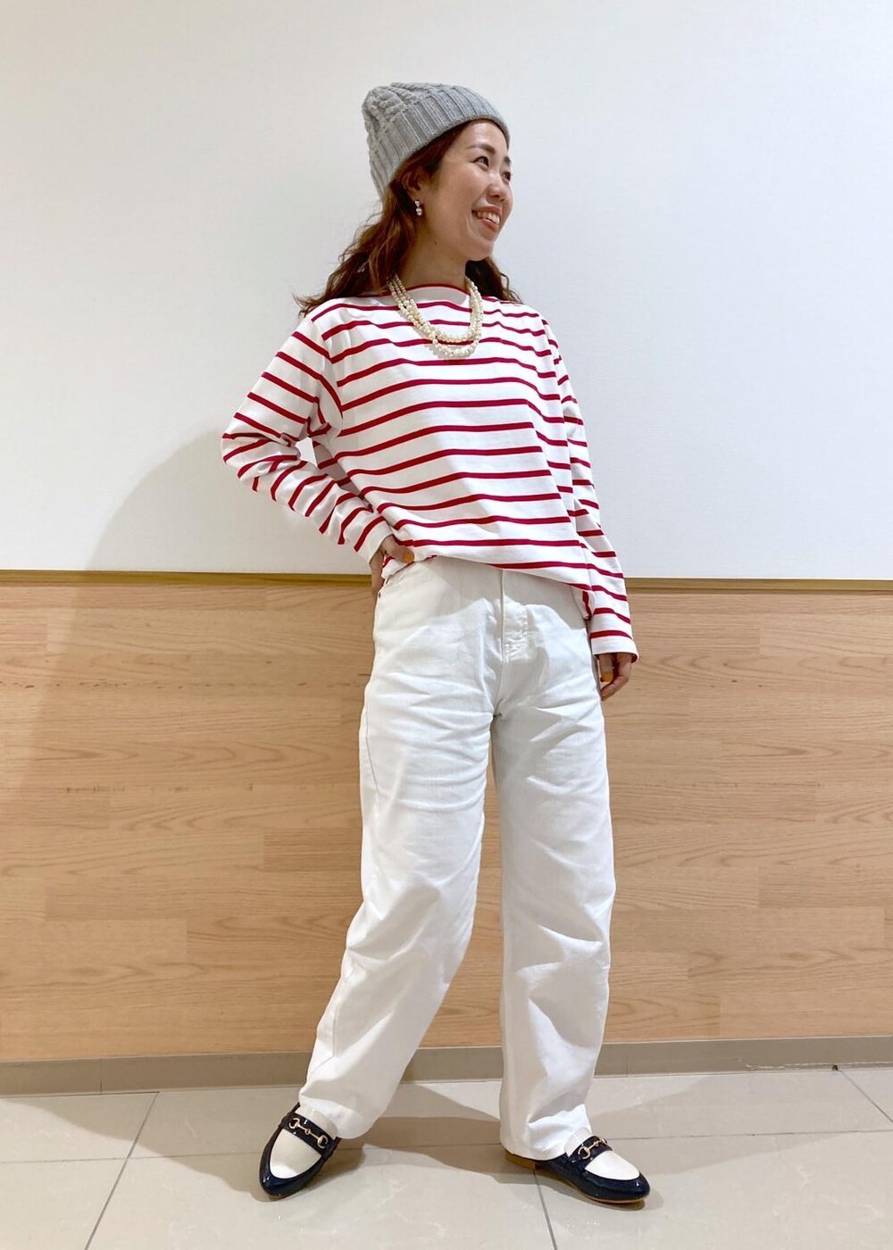 ベージュ系のトレンチコート、レッド系のTシャツ/カットソー、ホワイト系のデニムパンツを着用したレディースの春コーディネートの2枚目の写真