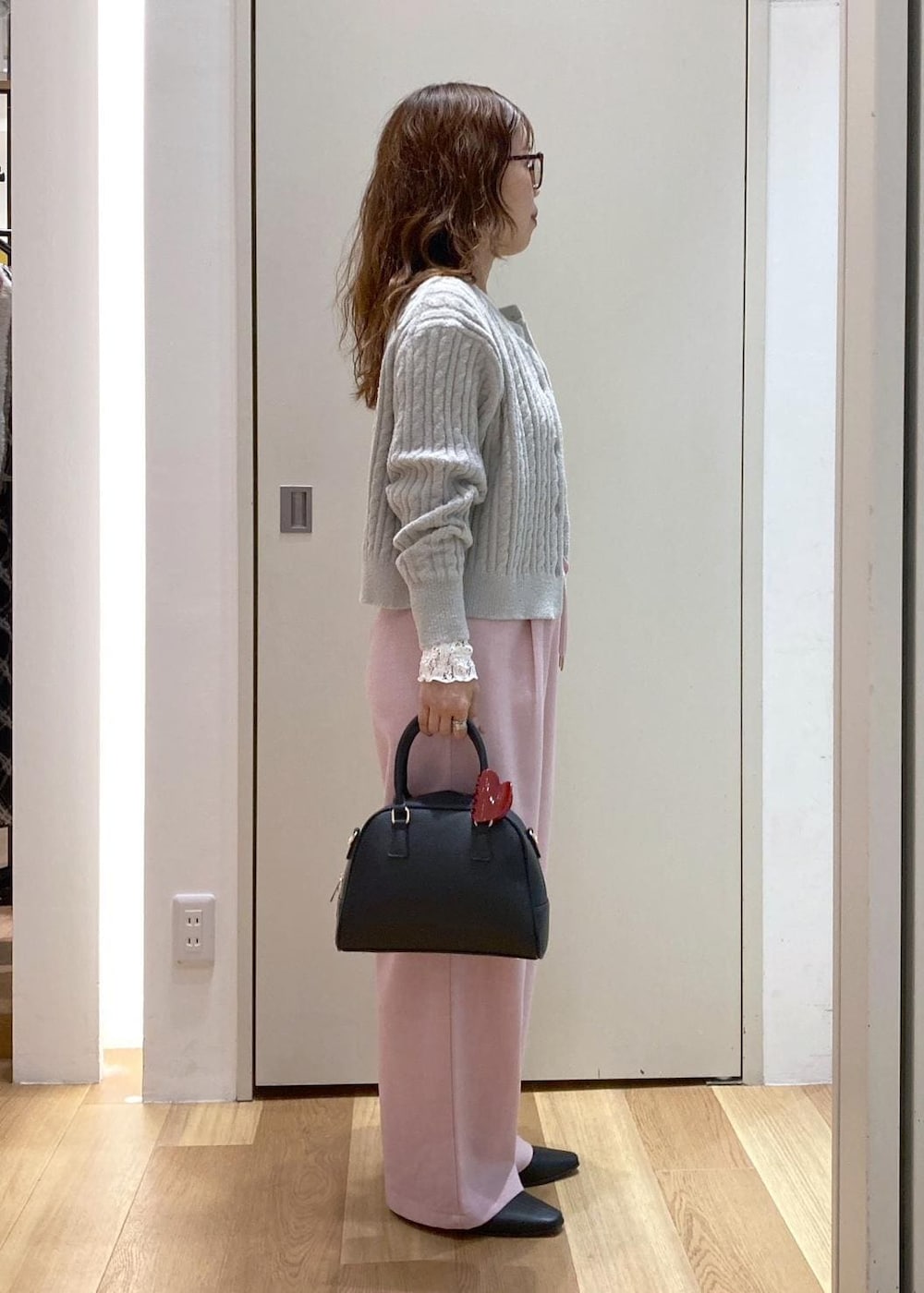 ピンク系のその他パンツ、グレー系のカーディガン/ボレロ、ブラック系のブーツを着用したレディースの秋コーディネートの2枚目の写真