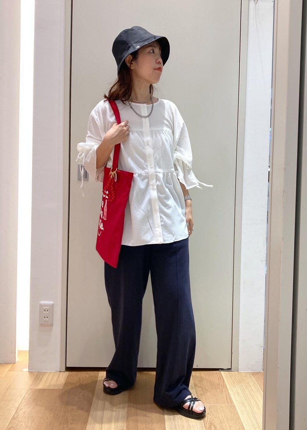 ブルー系のその他パンツ、ブラック系のサンダル、ホワイト系のシャツ/ブラウスを着用したレディースの夏コーディネートの2枚目の写真