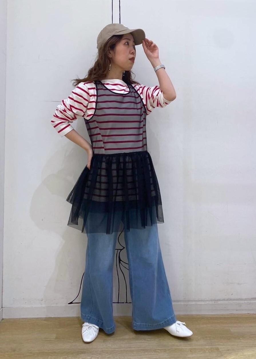 ブラック系のベスト、レッド系のTシャツ/カットソー、ホワイト系のパンプスを着用したレディースの春コーディネートの2枚目の写真