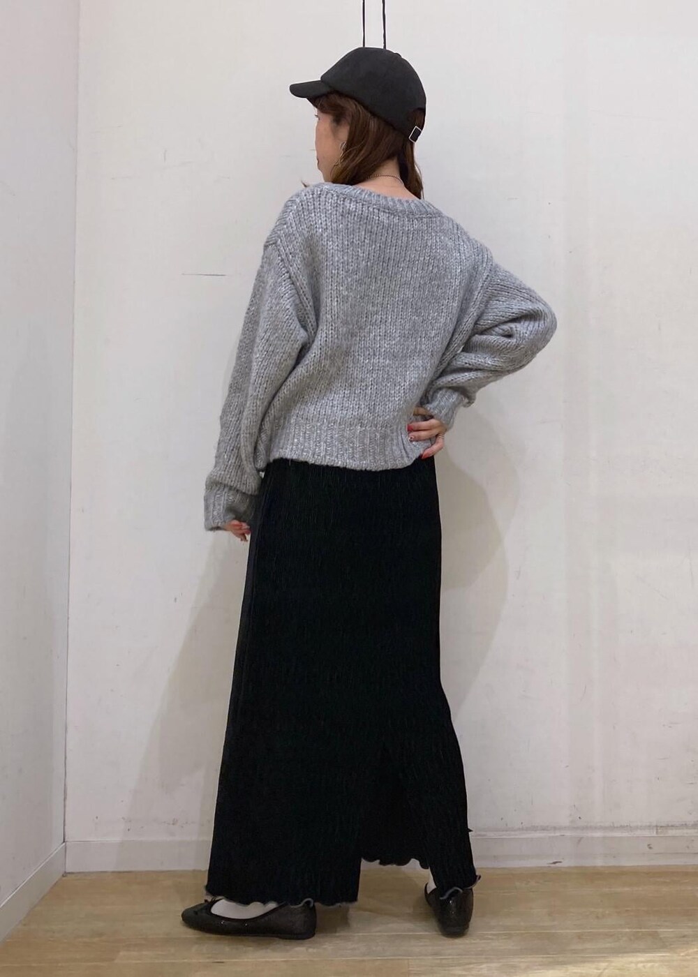 ホワイト系のTシャツ/カットソー、グレー系のニット/セーター、レッド系のトートバッグを着用したレディースの冬コーディネートの4枚目の写真