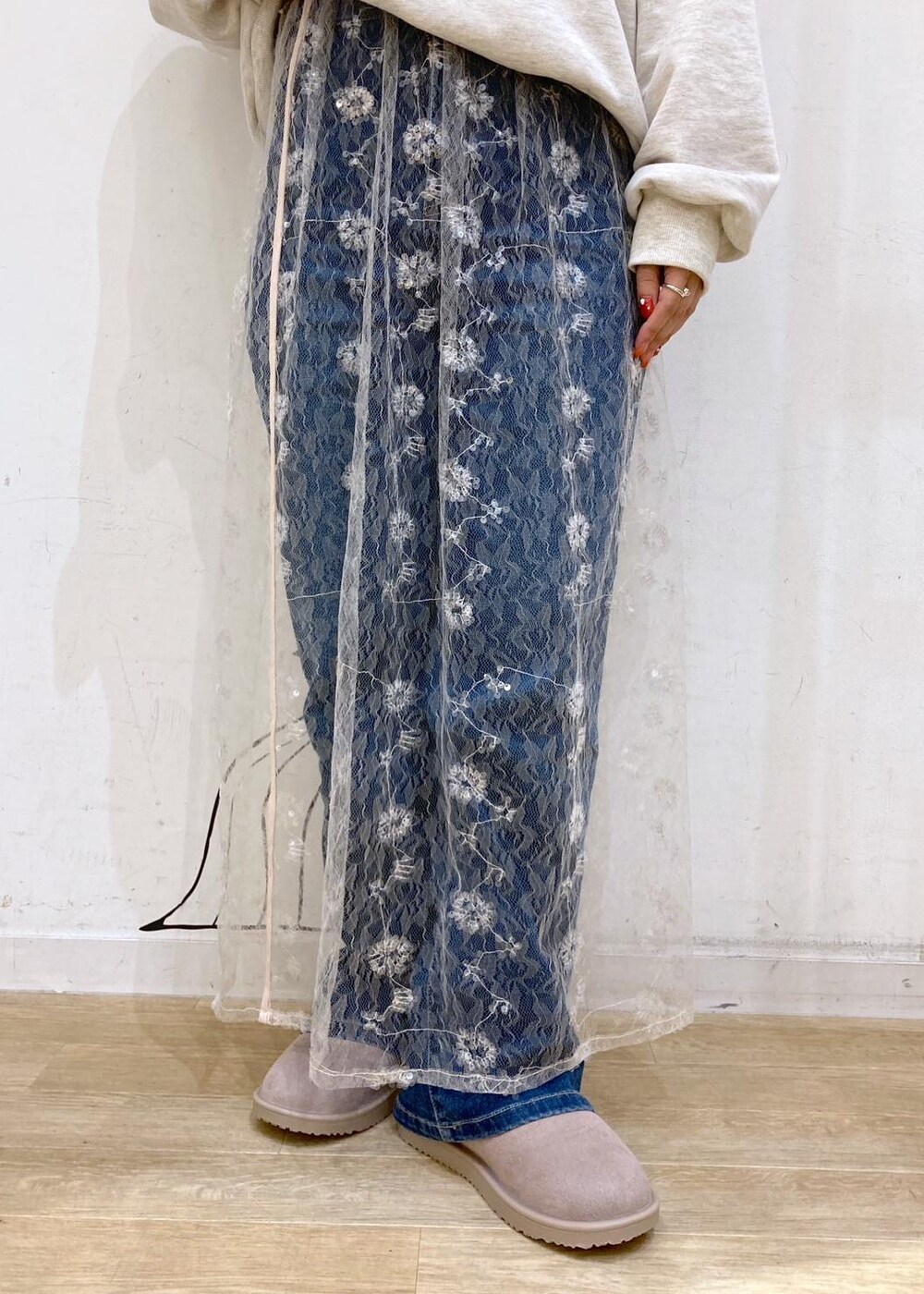 ブルー系のデニムパンツ、ホワイト系のスカート、ゴールド系のショルダーバッグを着用したレディースの秋コーディネートの8枚目の写真