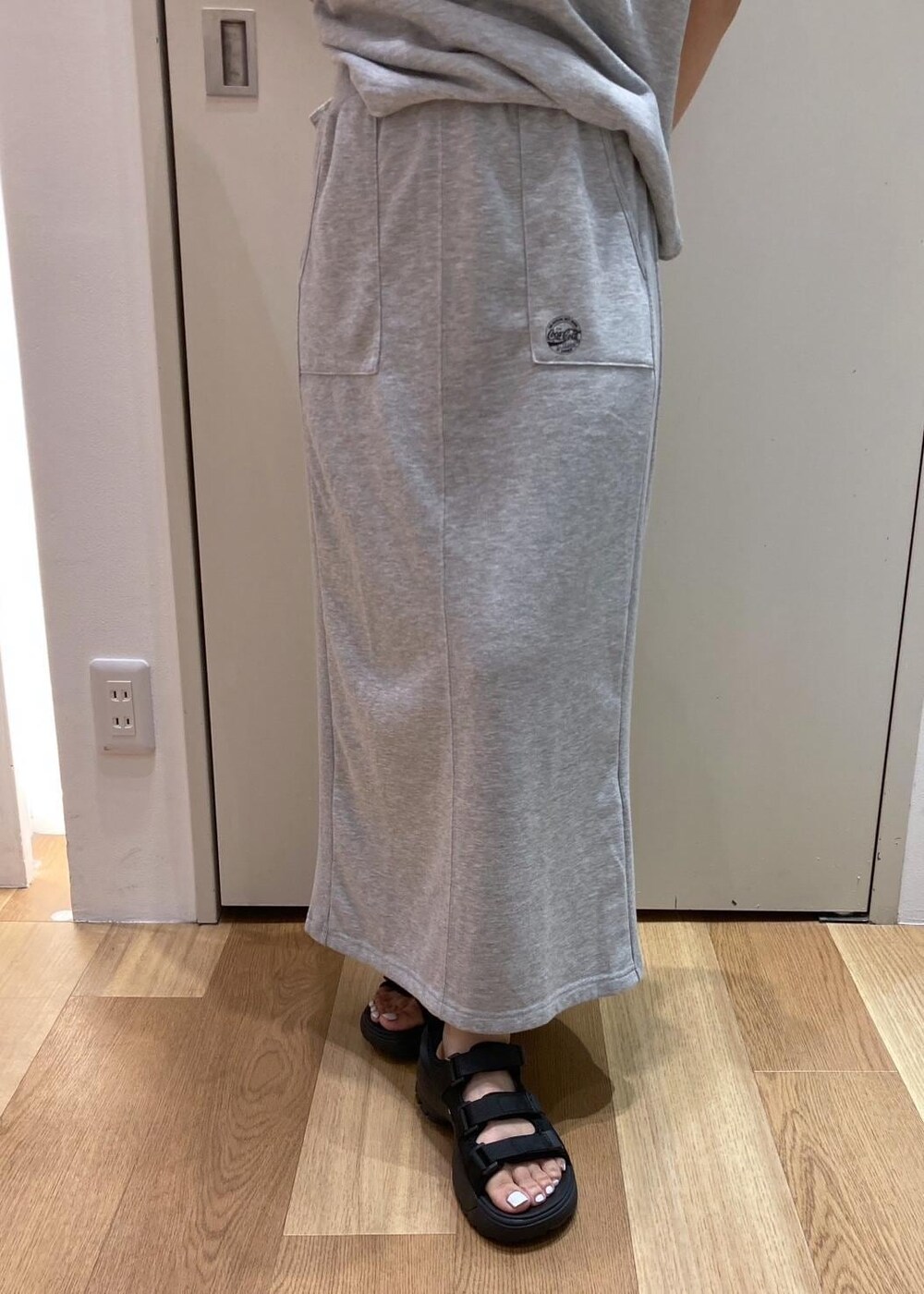 ブラック系のサンダル、レッド系のトートバッグ、グレー系のスカートを着用したレディースの夏コーディネートの5枚目の写真