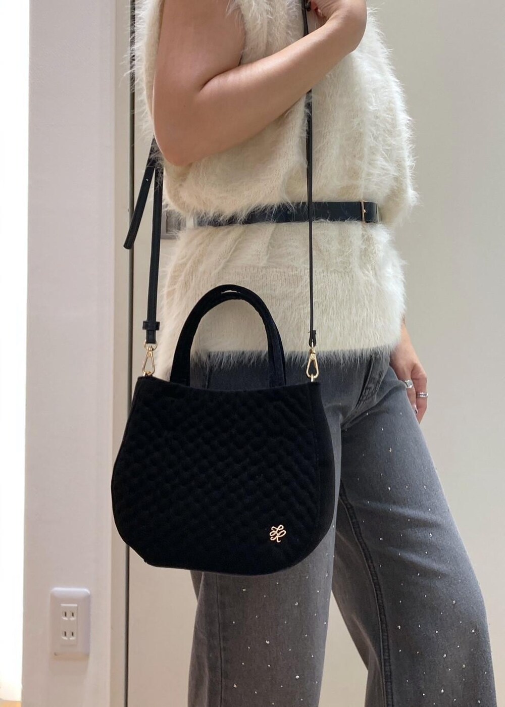 ホワイト系のベスト、ブラック系のデニムパンツ、ブラック系のショルダーバッグを着用したレディースの夏コーディネートの8枚目の写真