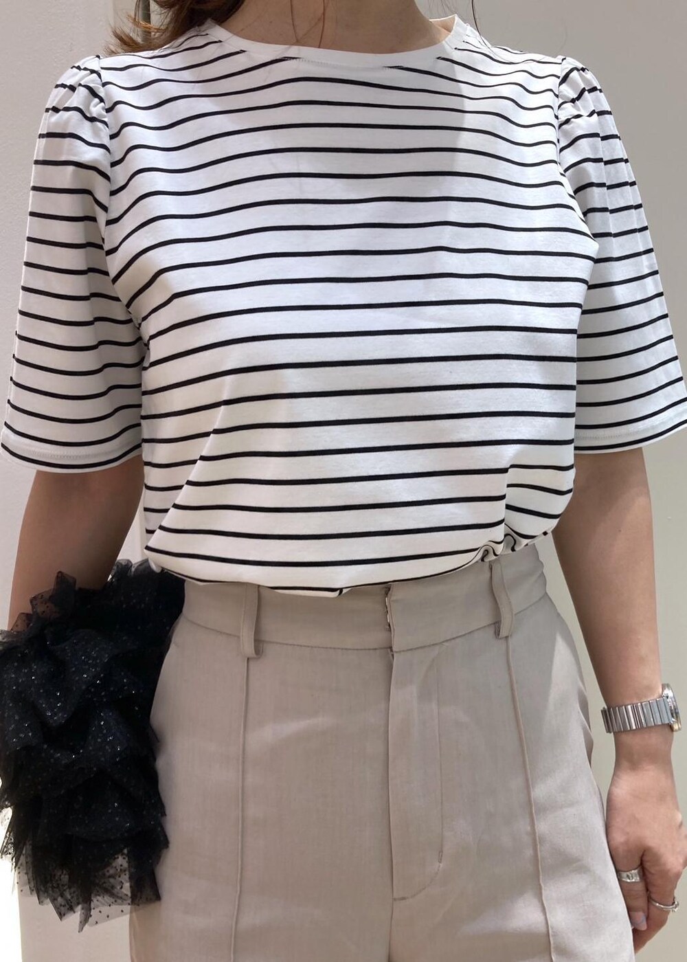 ブラック系のショルダーバッグ、シルバー系のパンプス、ベージュ系のその他パンツを着用したレディースの夏コーディネートの4枚目の写真