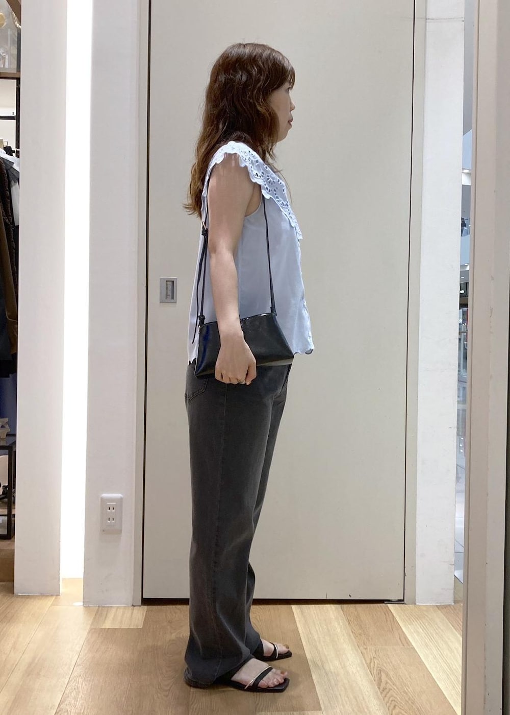 ブラック系のデニムパンツ、ブラック系のショルダーバッグ、ブラック系のサンダルを着用したレディースの夏コーディネートの2枚目の写真
