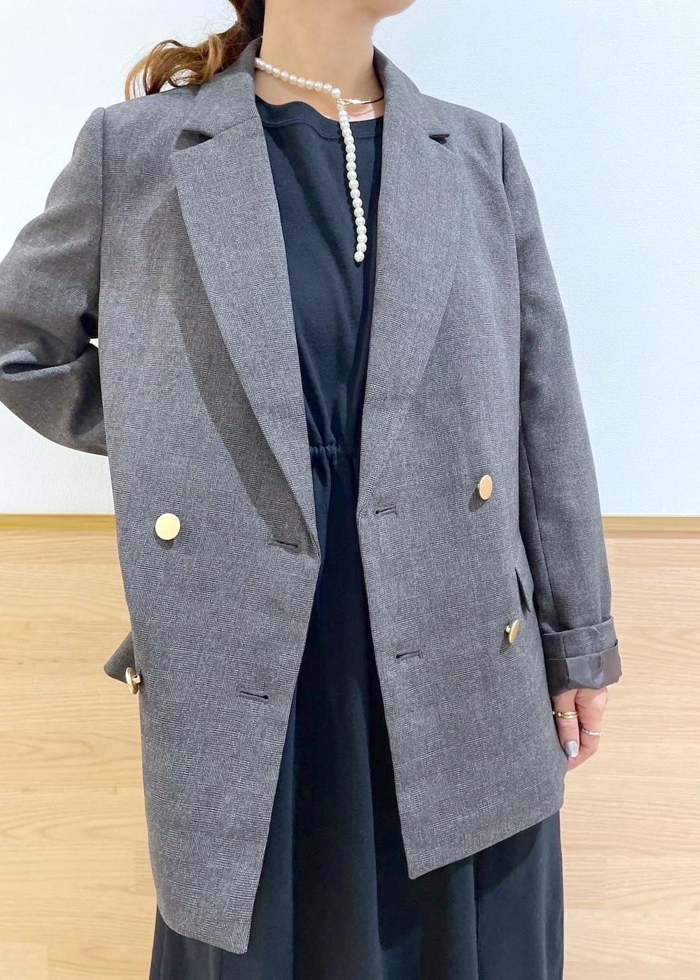 ブラウン系のテーラードジャケット、ブラック系のハンドバッグ、ブラック系のワンピースを着用したレディースの秋コーディネートの5枚目の写真