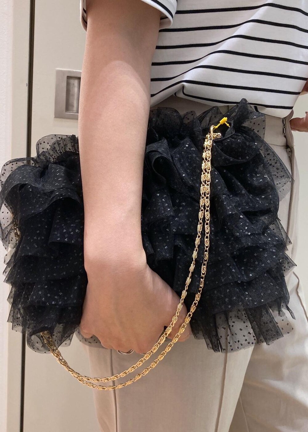 ブラック系のショルダーバッグ、シルバー系のパンプス、ベージュ系のその他パンツを着用したレディースの夏コーディネートの6枚目の写真