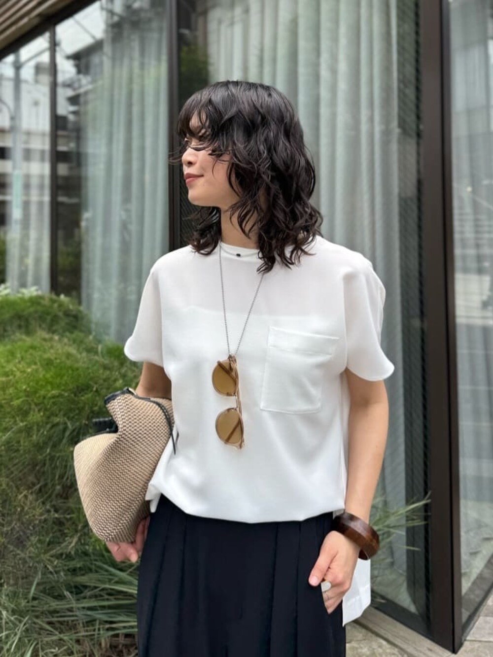 ブラック系のスラックス、ホワイト系のシャツ/ブラウス、ブラック系のトートバッグを着用したレディースの夏コーディネートの6枚目の写真