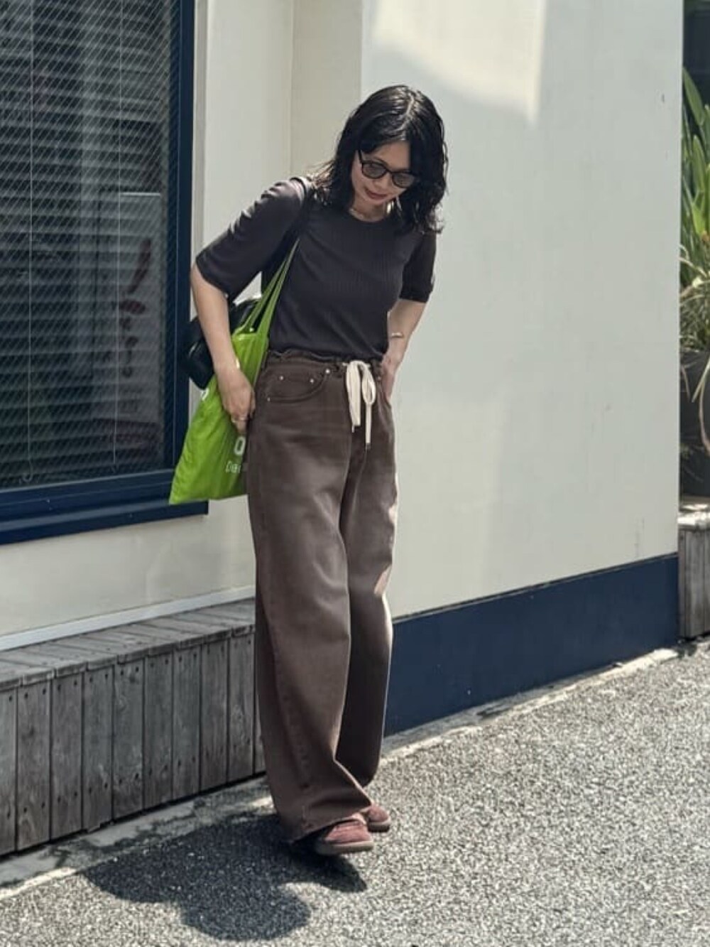 ブラウン系のその他パンツ、ブラック系のショルダーバッグ、グレー系のTシャツ/カットソーを着用したレディースの夏コーディネートの3枚目の写真