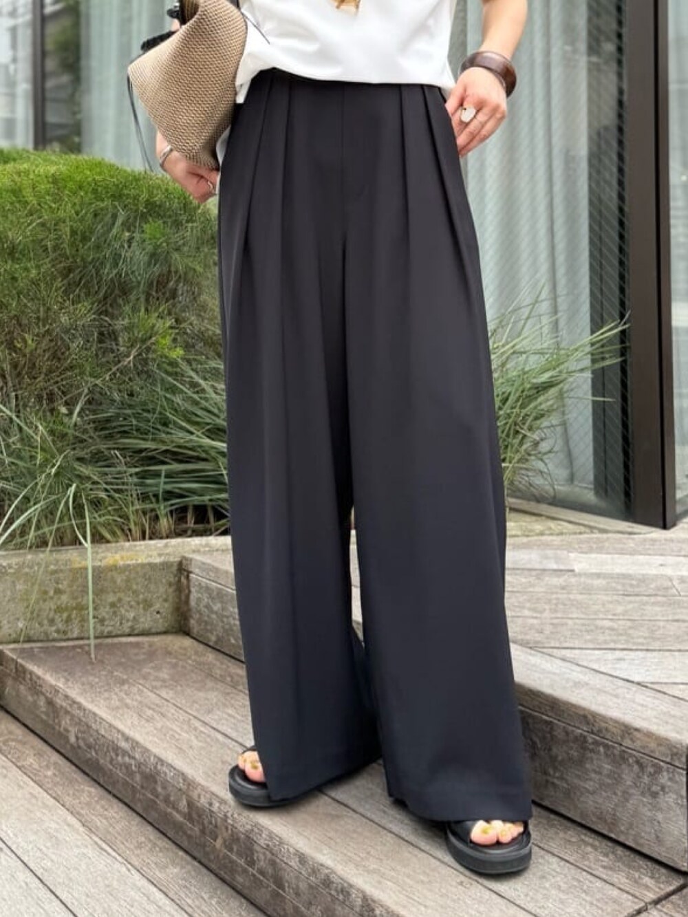 ブラック系のスラックス、ホワイト系のシャツ/ブラウス、ブラック系のトートバッグを着用したレディースの夏コーディネートの5枚目の写真