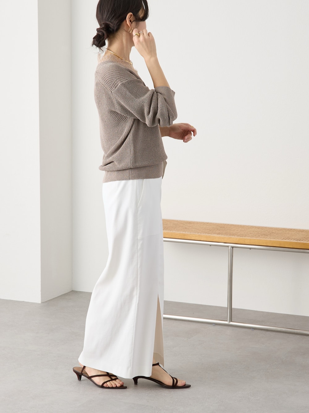 ブラウン系のニット/セーター、ホワイト系のスカート、ブラック系のサンダルを着用したレディースの冬コーディネートの2枚目の写真