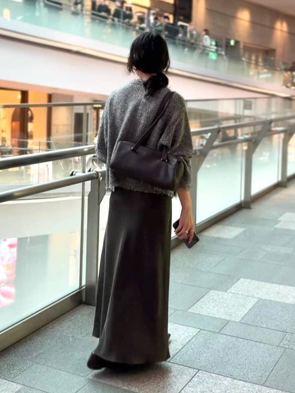 ブラウン系のスカート、ブラック系のその他シューズ、グレー系のカーディガン/ボレロを着用したレディースの夏コーディネートの4枚目の写真