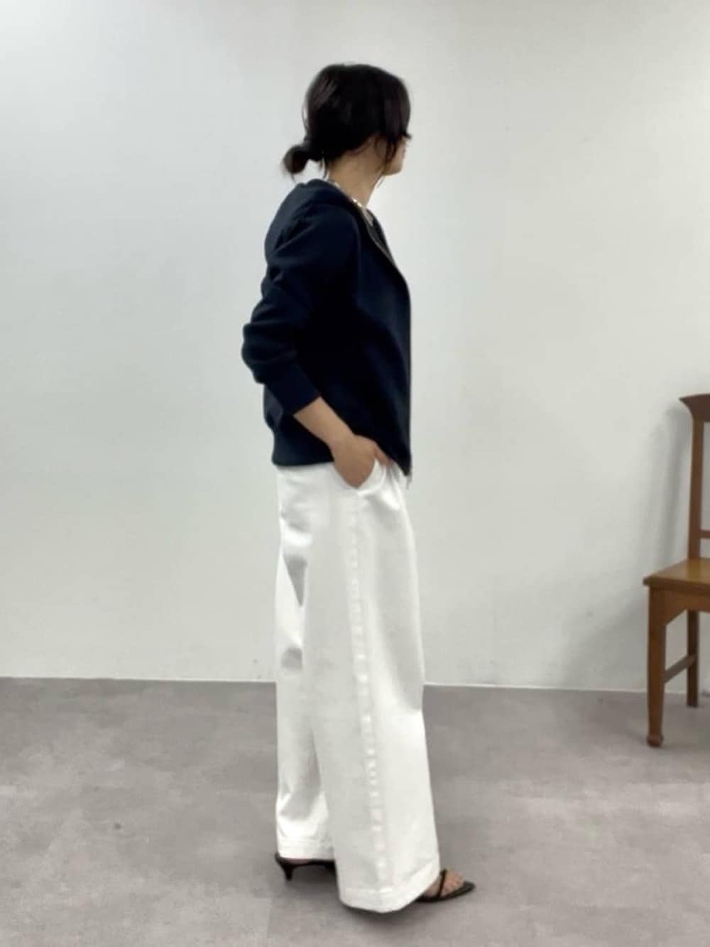 ホワイト系のデニムパンツ、ブラック系のサンダル、ブルー系のパーカーを着用したレディースの冬コーディネートの2枚目の写真