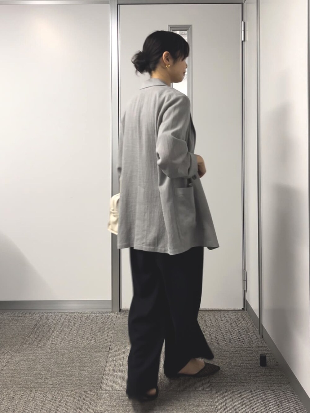 グレー系のニット/セーター、グレー系のテーラードジャケットを着用したレディースの春コーディネートの3枚目の写真