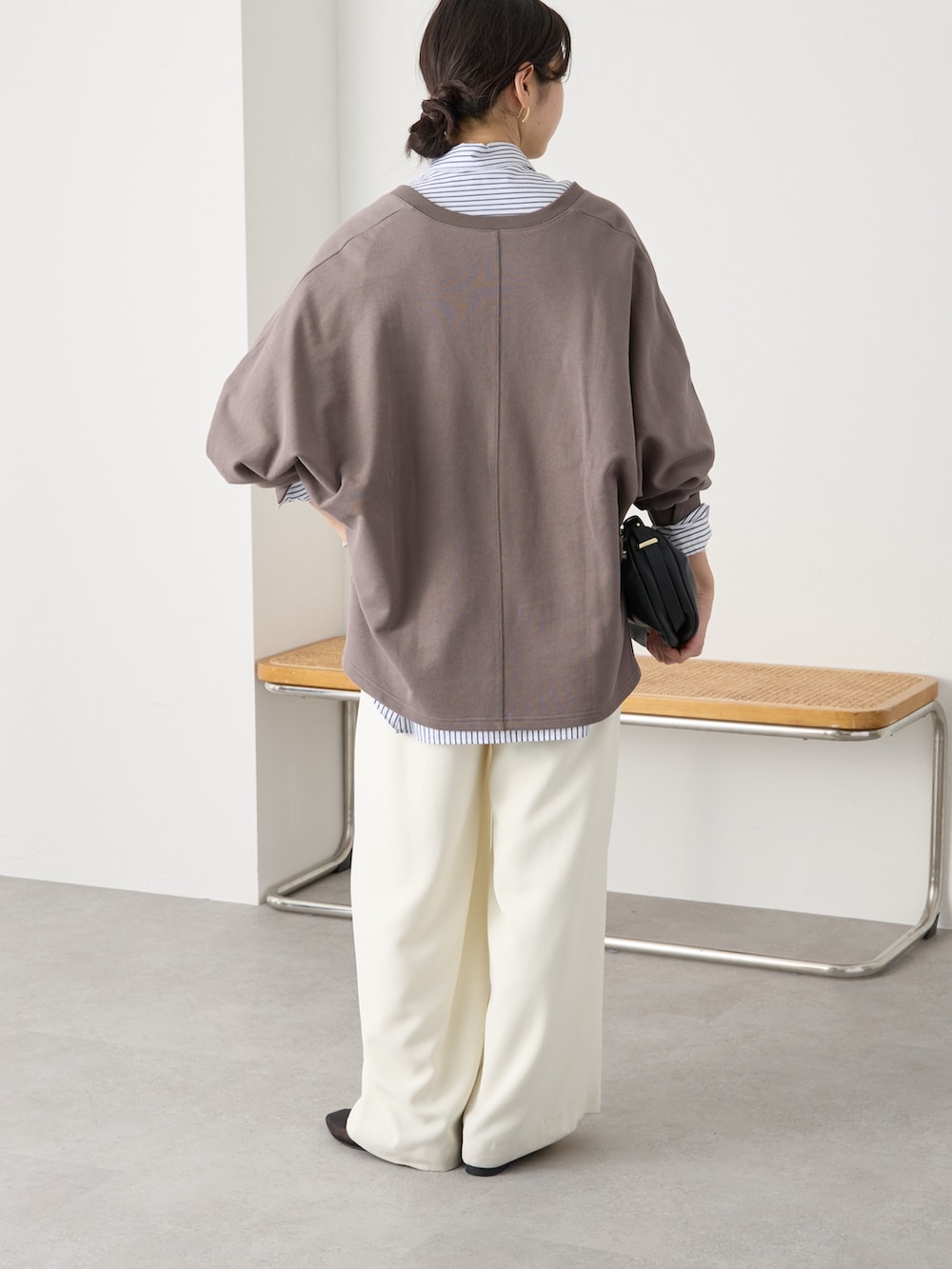 ブラウン系のスウェット、ホワイト系のスラックス、ブラック系のその他シューズを着用したレディースの冬コーディネートの4枚目の写真