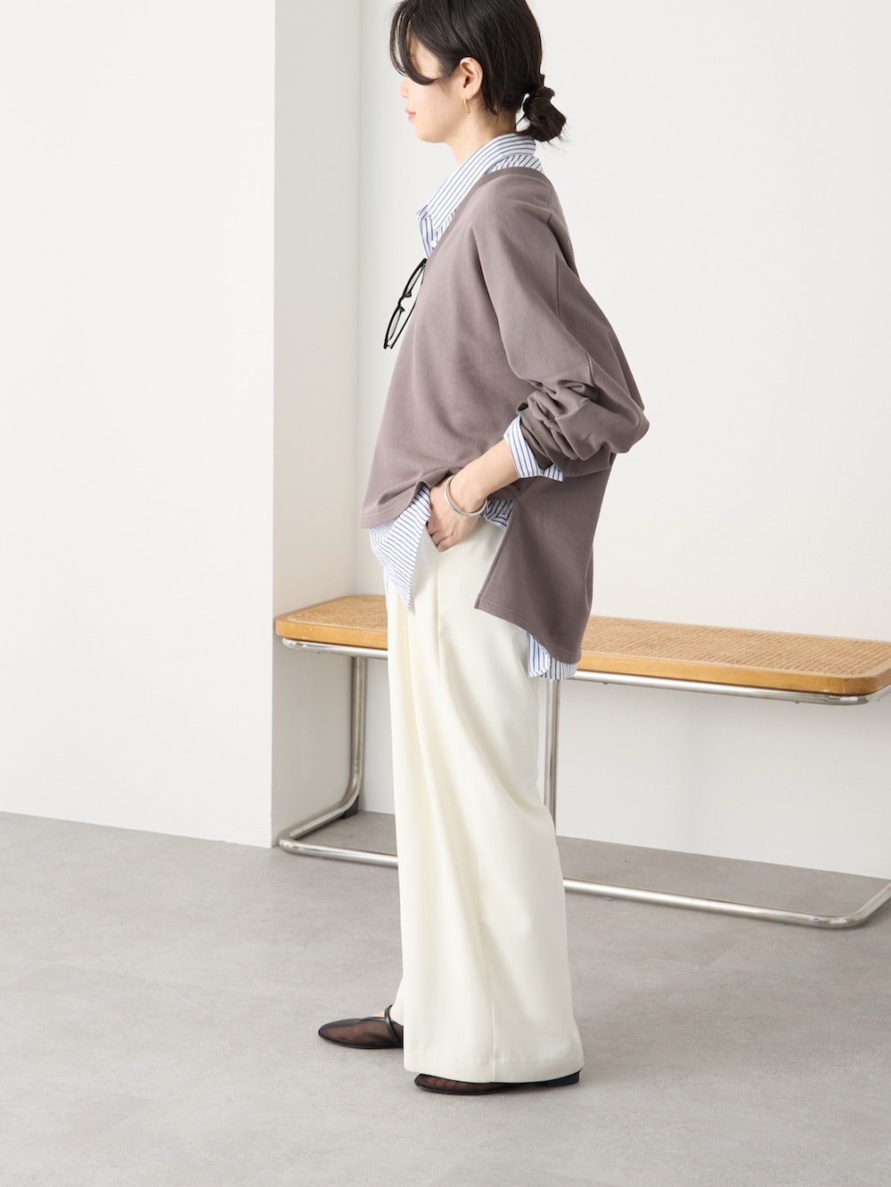 ブラウン系のスウェット、ホワイト系のスラックス、ブラック系のその他シューズを着用したレディースの冬コーディネートの3枚目の写真