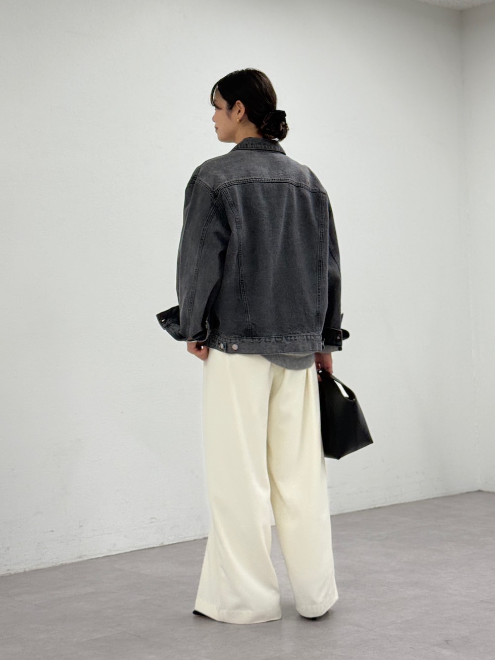 ホワイト系のスラックス、ブルー系のデニムジャケット、グレー系のニット/セーターを着用したレディースの秋コーディネートの3枚目の写真