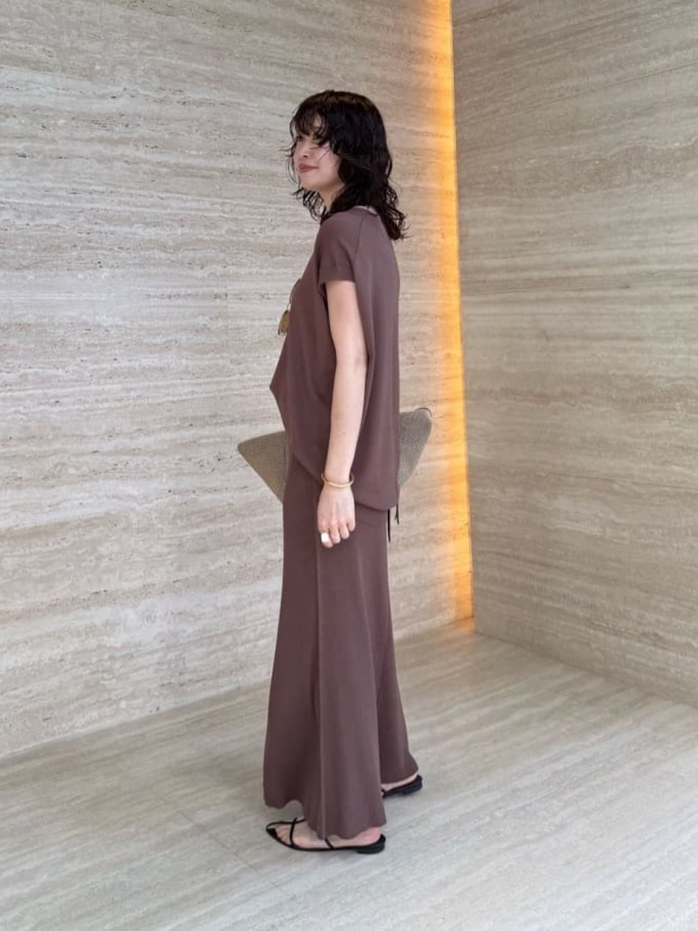 ブラウン系のスカート、ブラック系のトートバッグ、ブラウン系のニット/セーターを着用したレディースの夏コーディネートの3枚目の写真