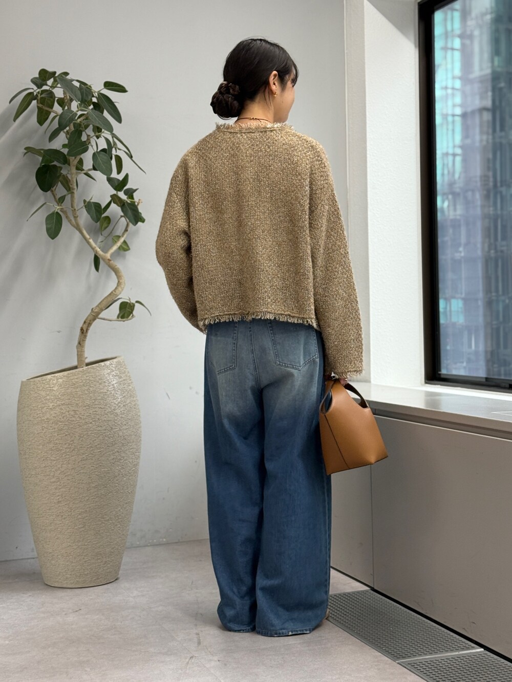 ブルー系のデニムパンツ、ベージュ系のカーディガン/ボレロ、ホワイト系のシャツ/ブラウスを着用したレディースの秋コーディネートの3枚目の写真