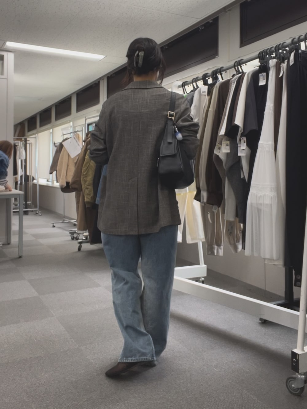 ブルー系のデニムパンツ、ブラック系のその他シューズ、ブラック系のTシャツ/カットソーを着用したレディースの春コーディネートの3枚目の写真