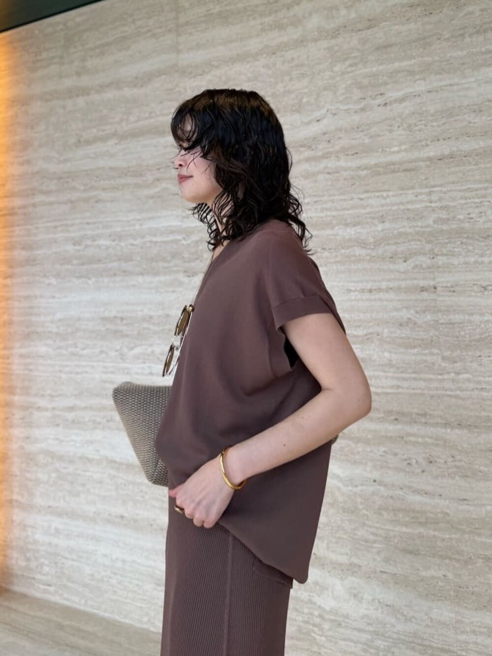 ブラウン系のスカート、ブラック系のトートバッグ、ブラウン系のニット/セーターを着用したレディースの夏コーディネートの5枚目の写真