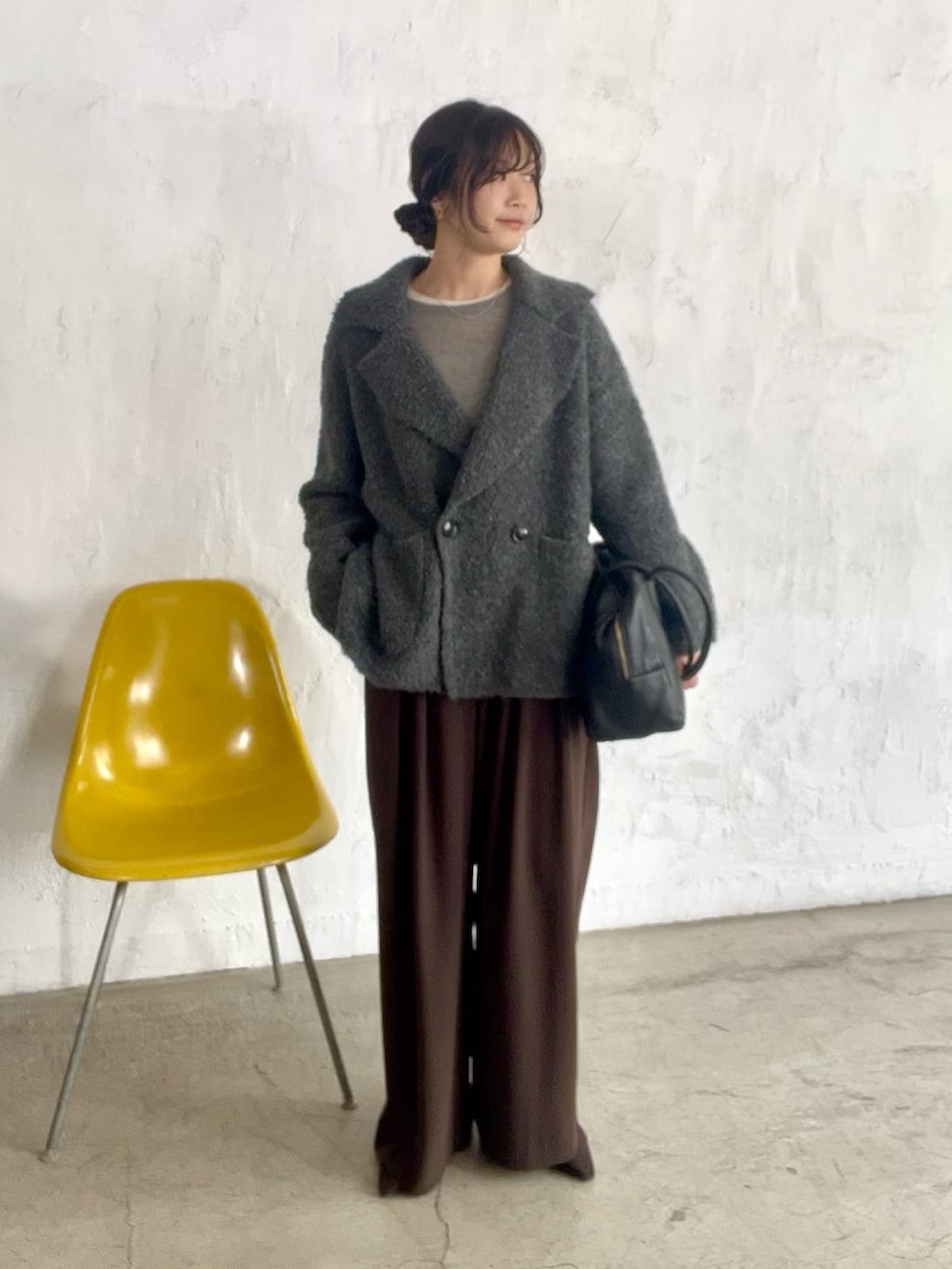 ブラウン系のスラックス、グレー系のその他アウター、ブラック系のボストンバッグを着用したレディースの秋コーディネートの2枚目の写真