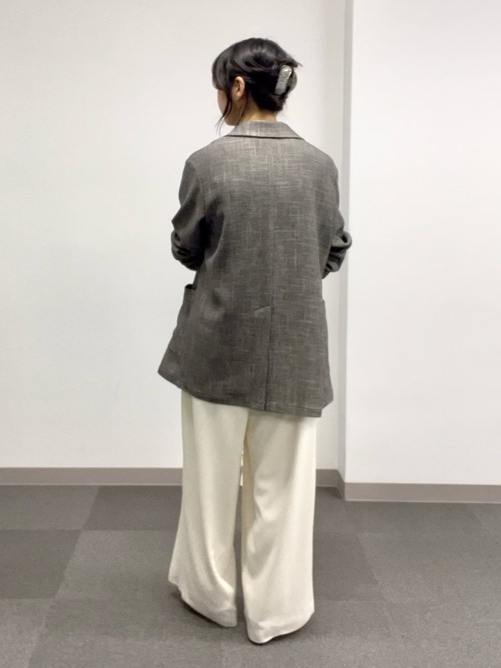 ブラック系のニット/セーター、ホワイト系のスラックス、グレー系のその他シューズを着用したレディースの春コーディネートの3枚目の写真