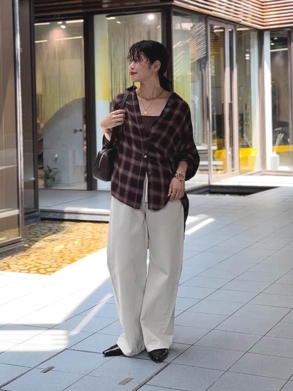 ベージュ系のシャツ/ブラウス、ブラック系のその他シューズ、ホワイト系のデニムパンツを着用したレディースの夏コーディネートの2枚目の写真