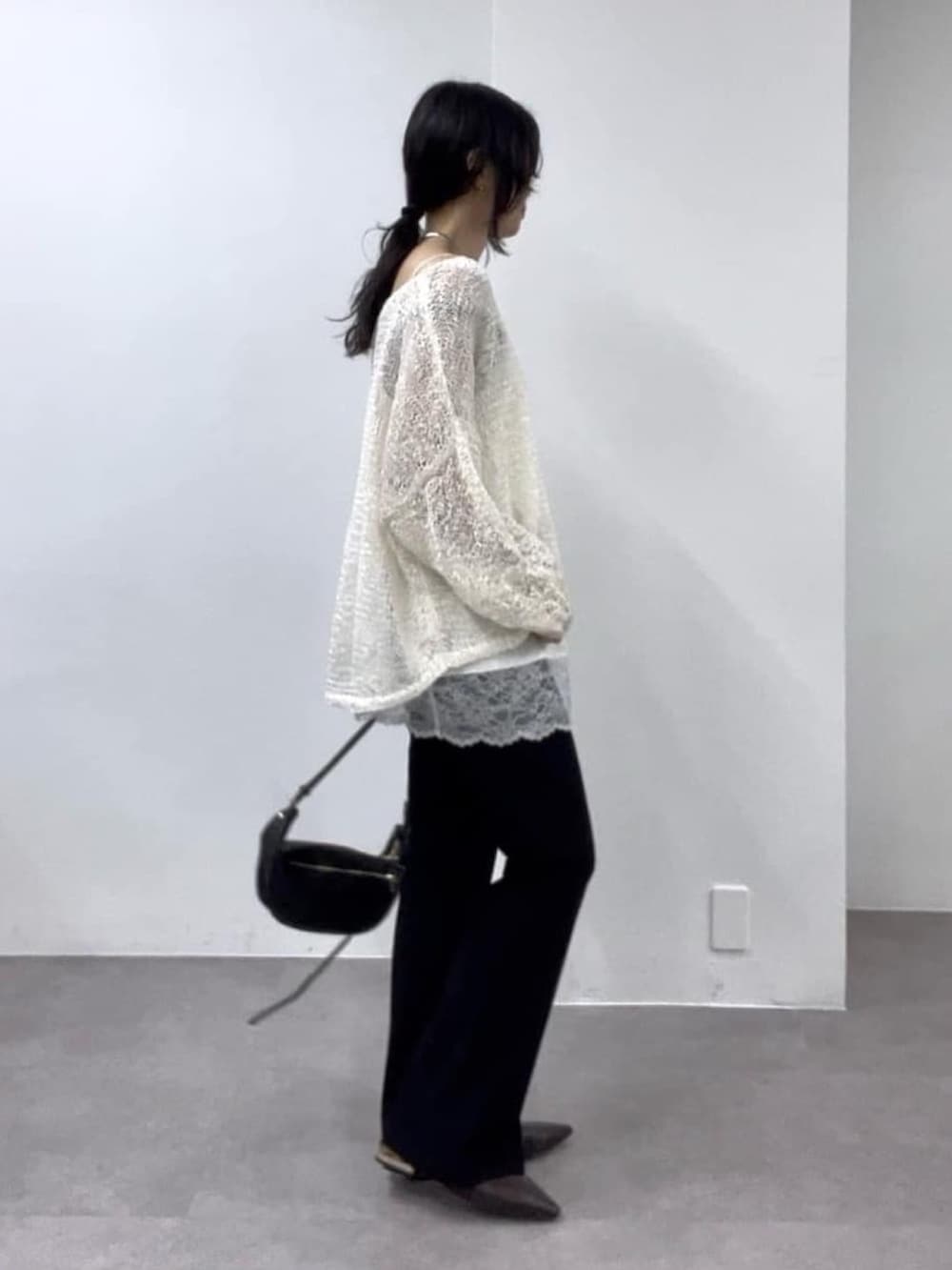 ホワイト系のニット/セーター、ホワイト系のキャミソール、ブラック系のその他パンツを着用したレディースの冬コーディネートの2枚目の写真